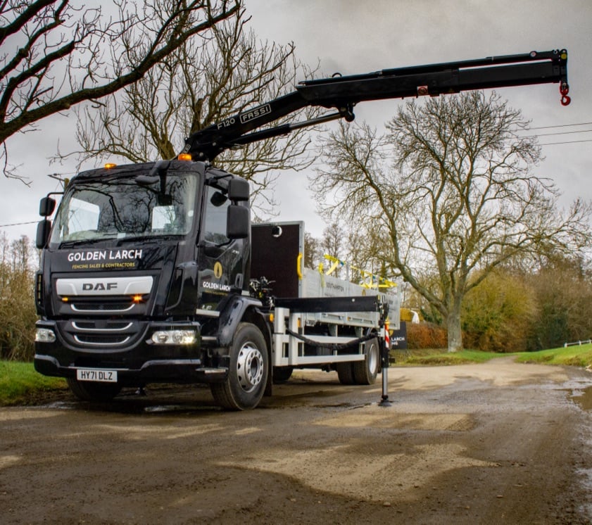 A Golden Larch Contracting truck with a crane on the back for lifting fence posts.