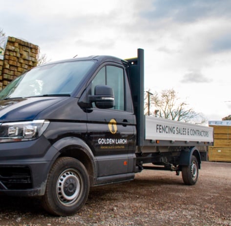 Golden Larch Contracting truck parked in a wood yard.